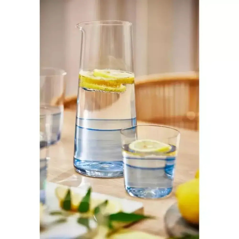 Clear glass carafe and cup with lemon slices