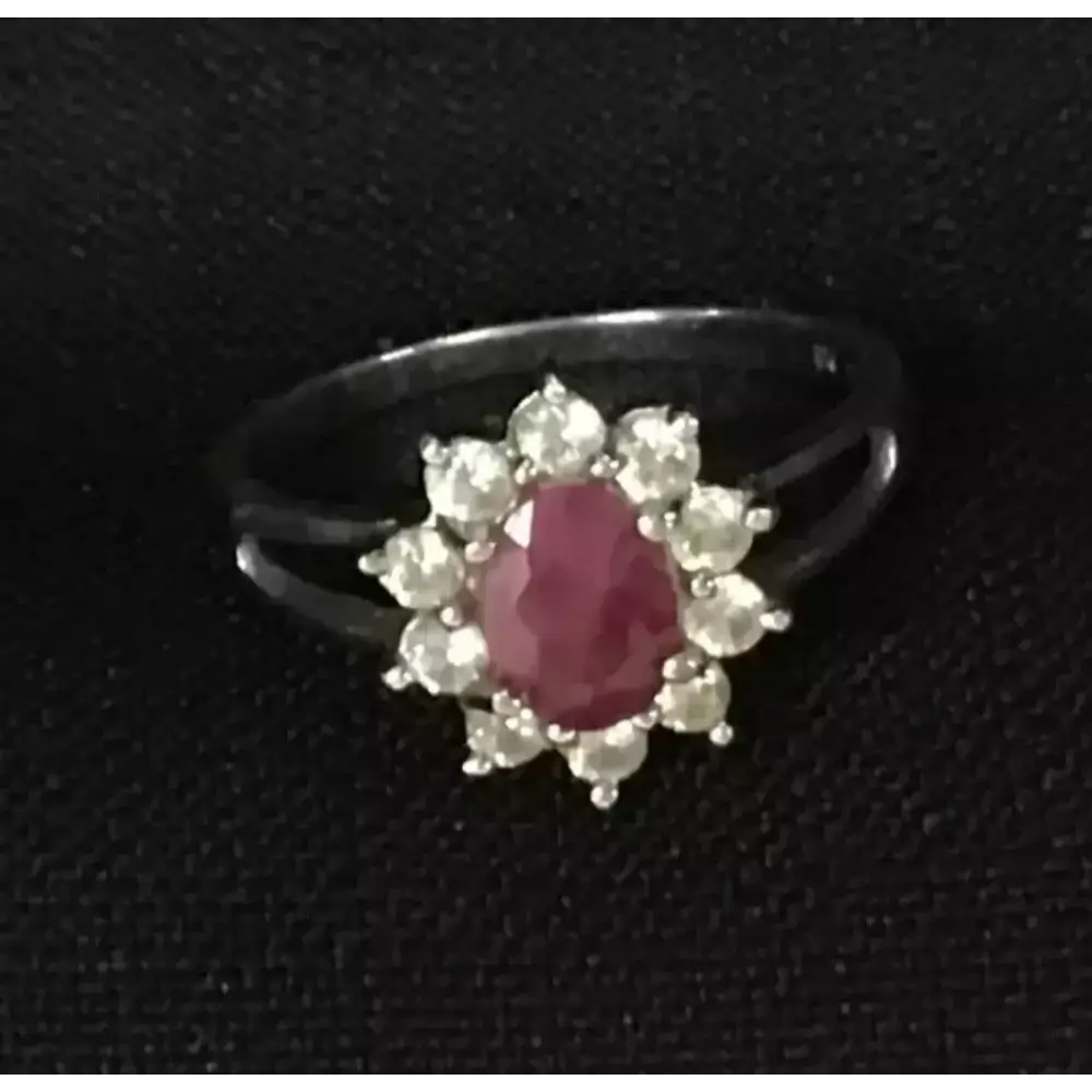 Ring with a red gemstone and pearl-like stones