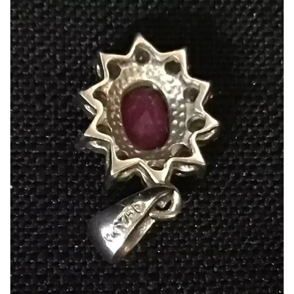 Gold pendant with a red gemstone