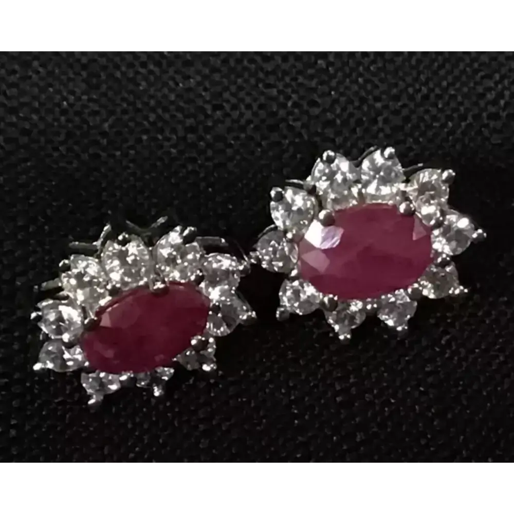 Pair of earrings with red gemstones and silver floral designs