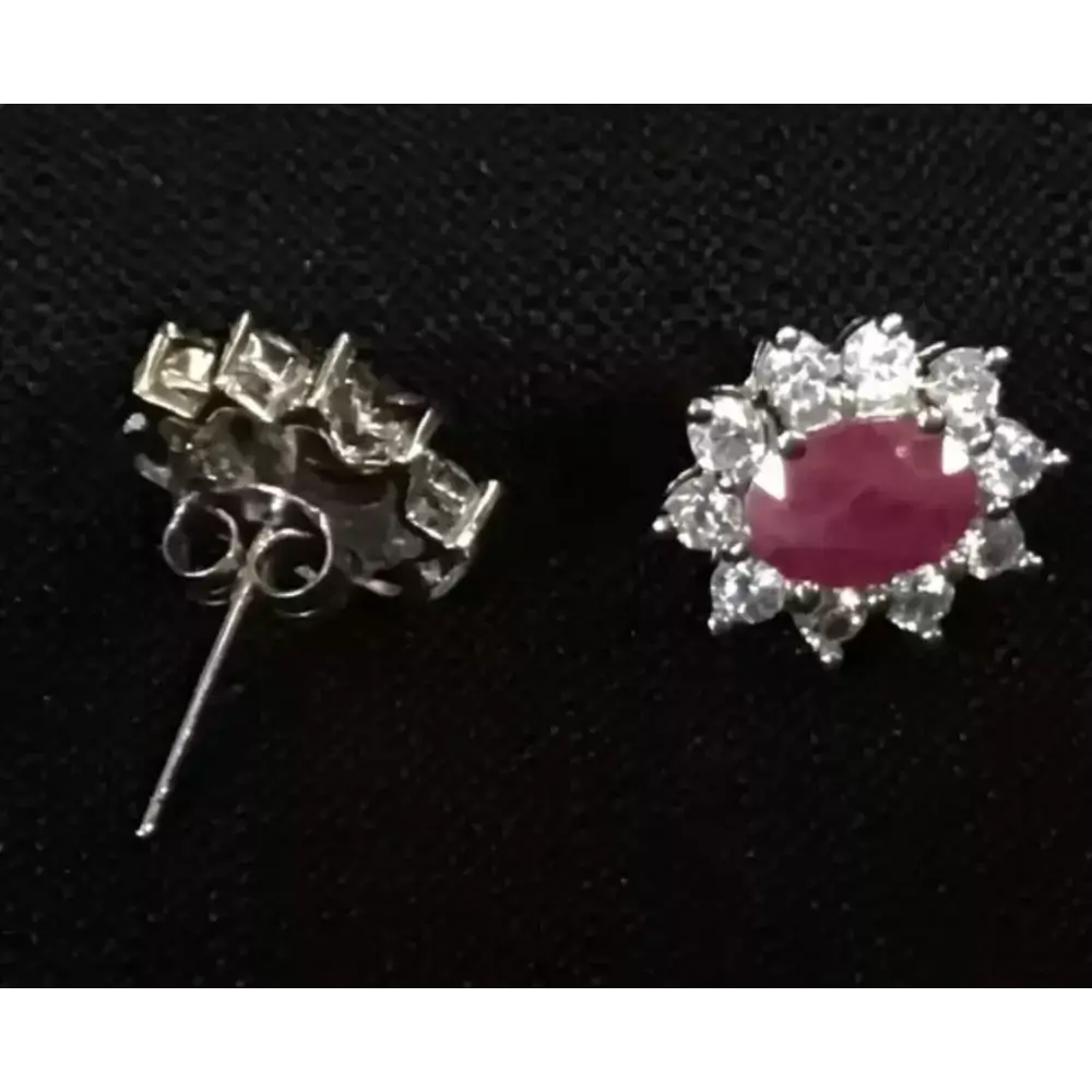 Pair of silver earrings with gemstones on a black background