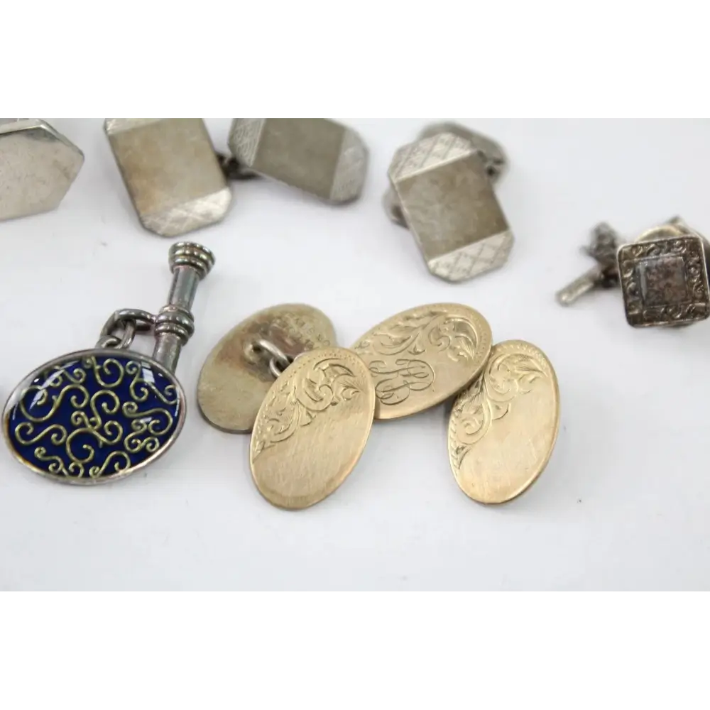 Collection of decorative metal cufflinks on a white background