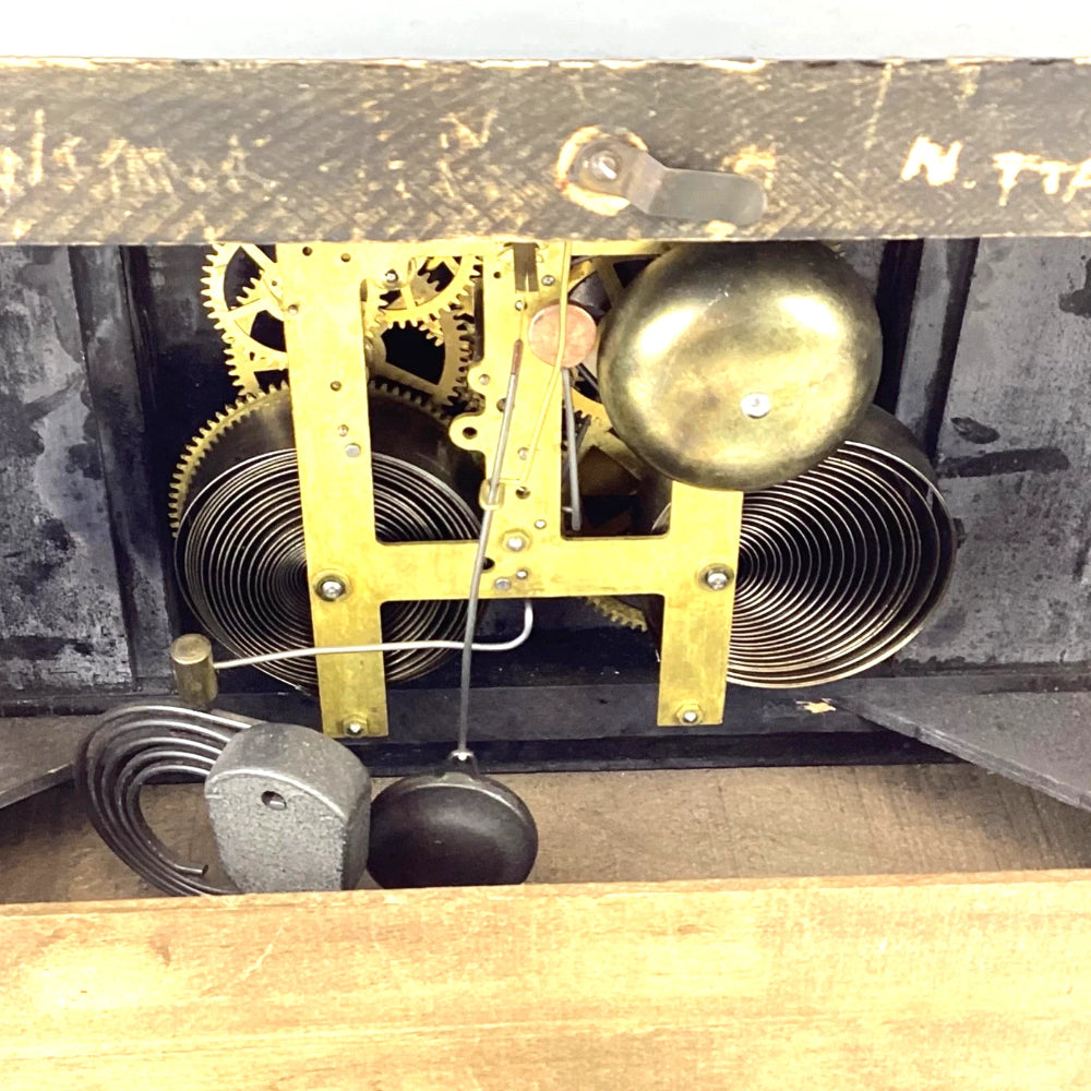 Close-up of a clock mechanism with gears and a pendulum inside