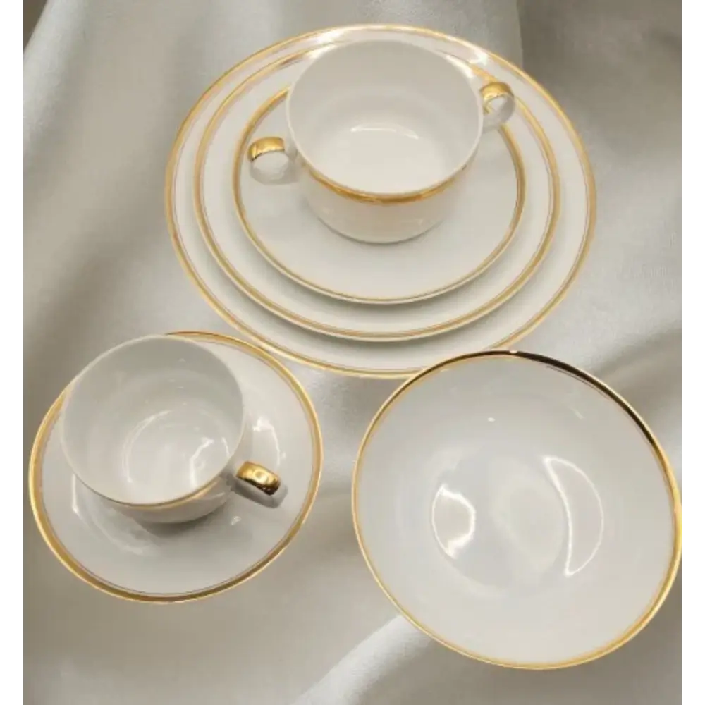 Set of white ceramic dinnerware with gold rims