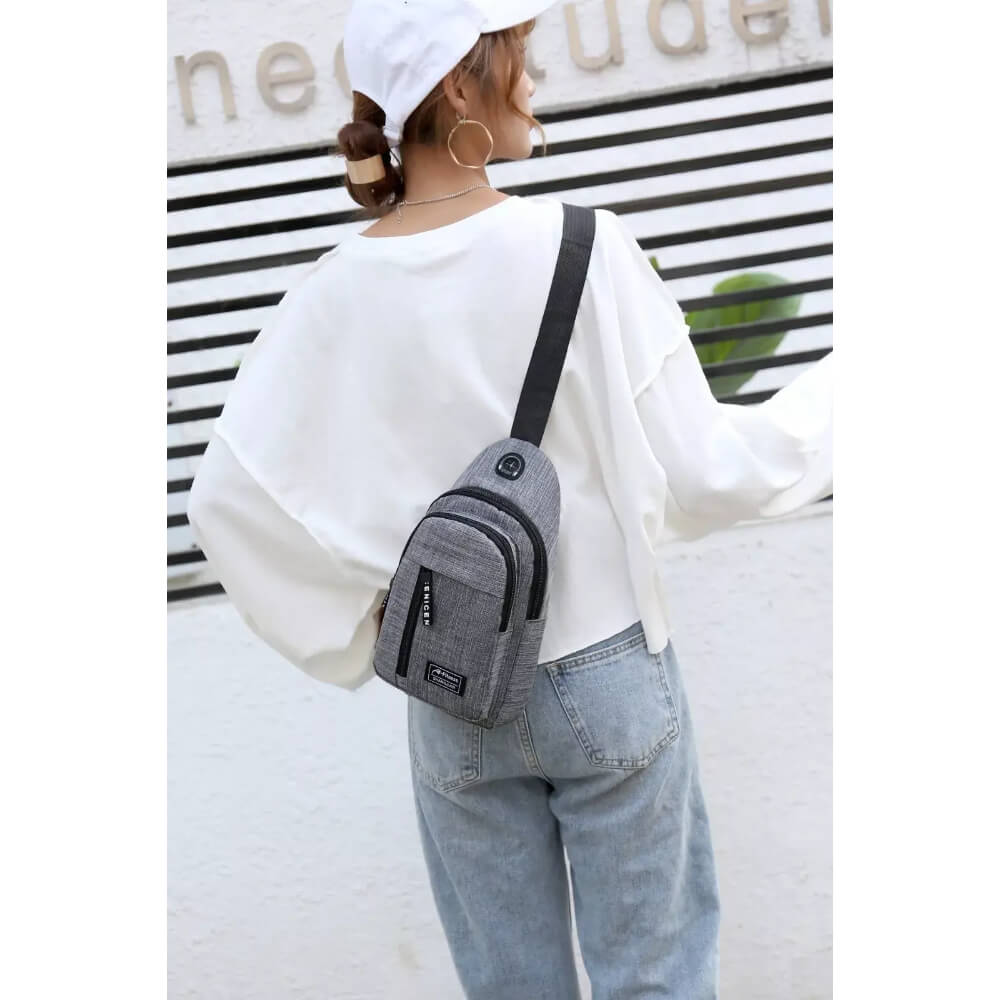 Person wearing a gray cross body bag