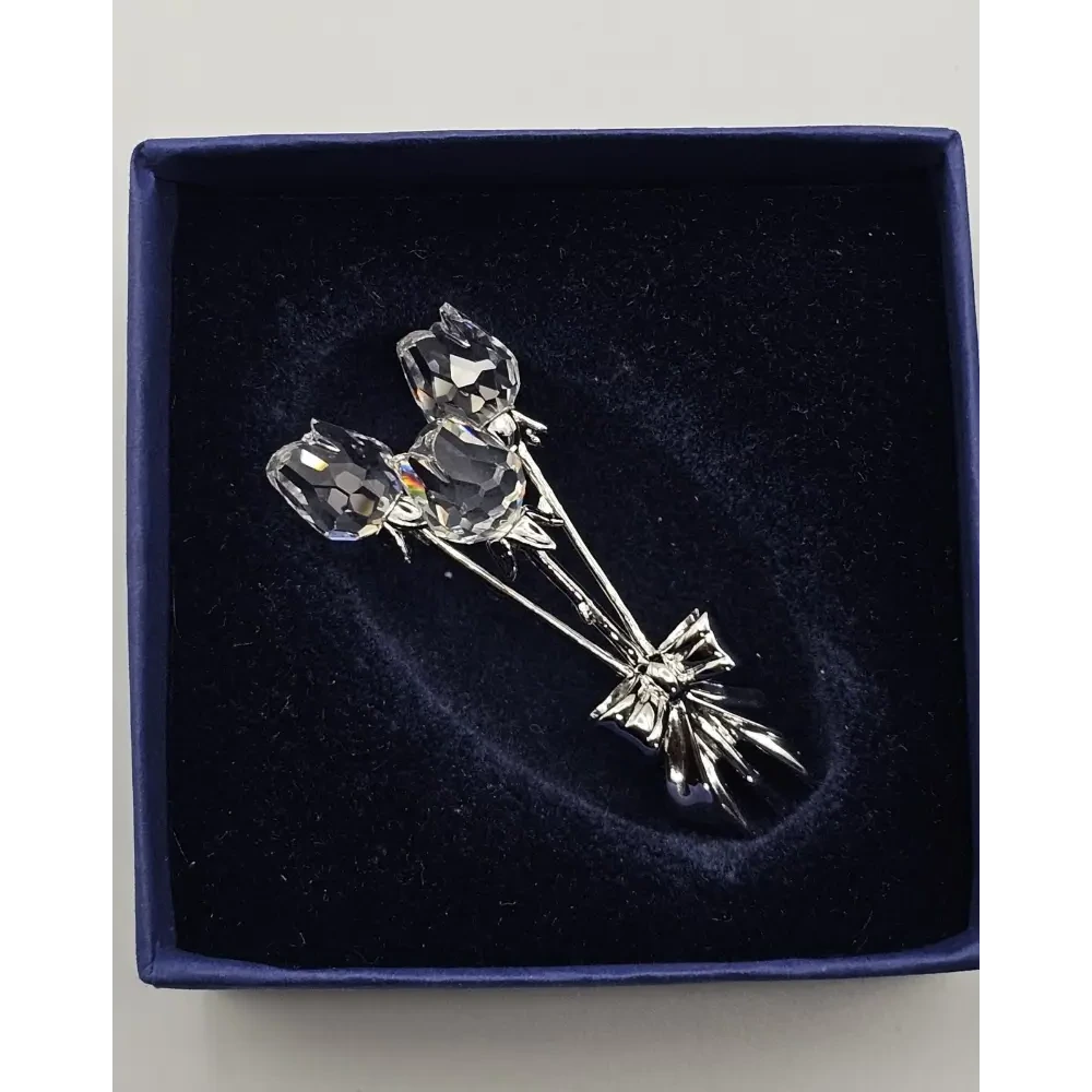 Silver rose brooch on a dark blue velvet background