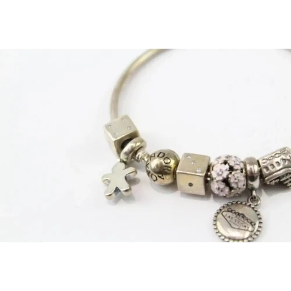 Silver charm bracelet with various charms on a white background
