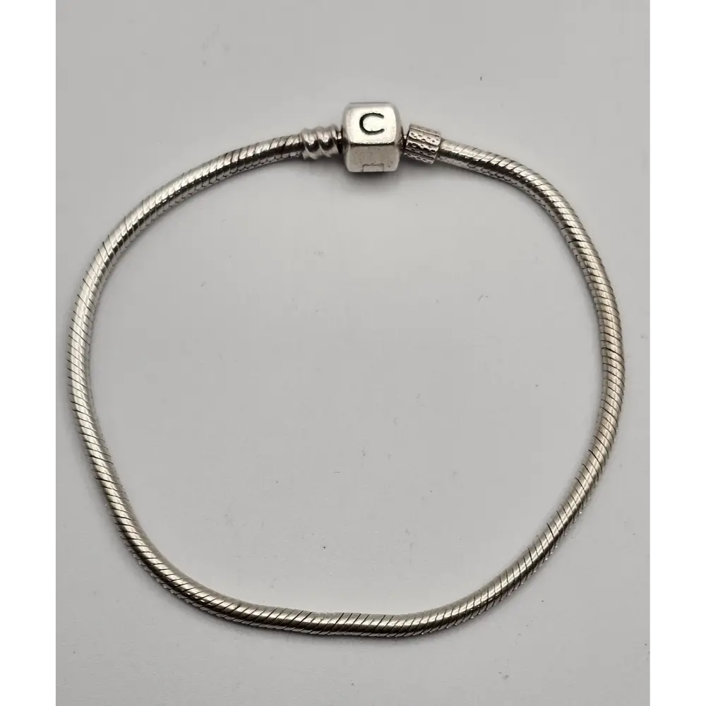 Silver bracelet with a cylindrical clasp on a gray background
