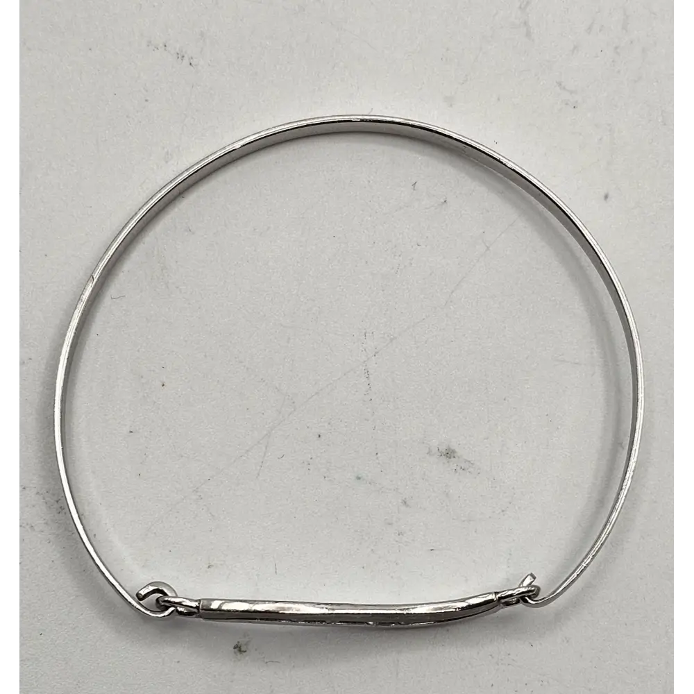 Silver bangle on a light gray background