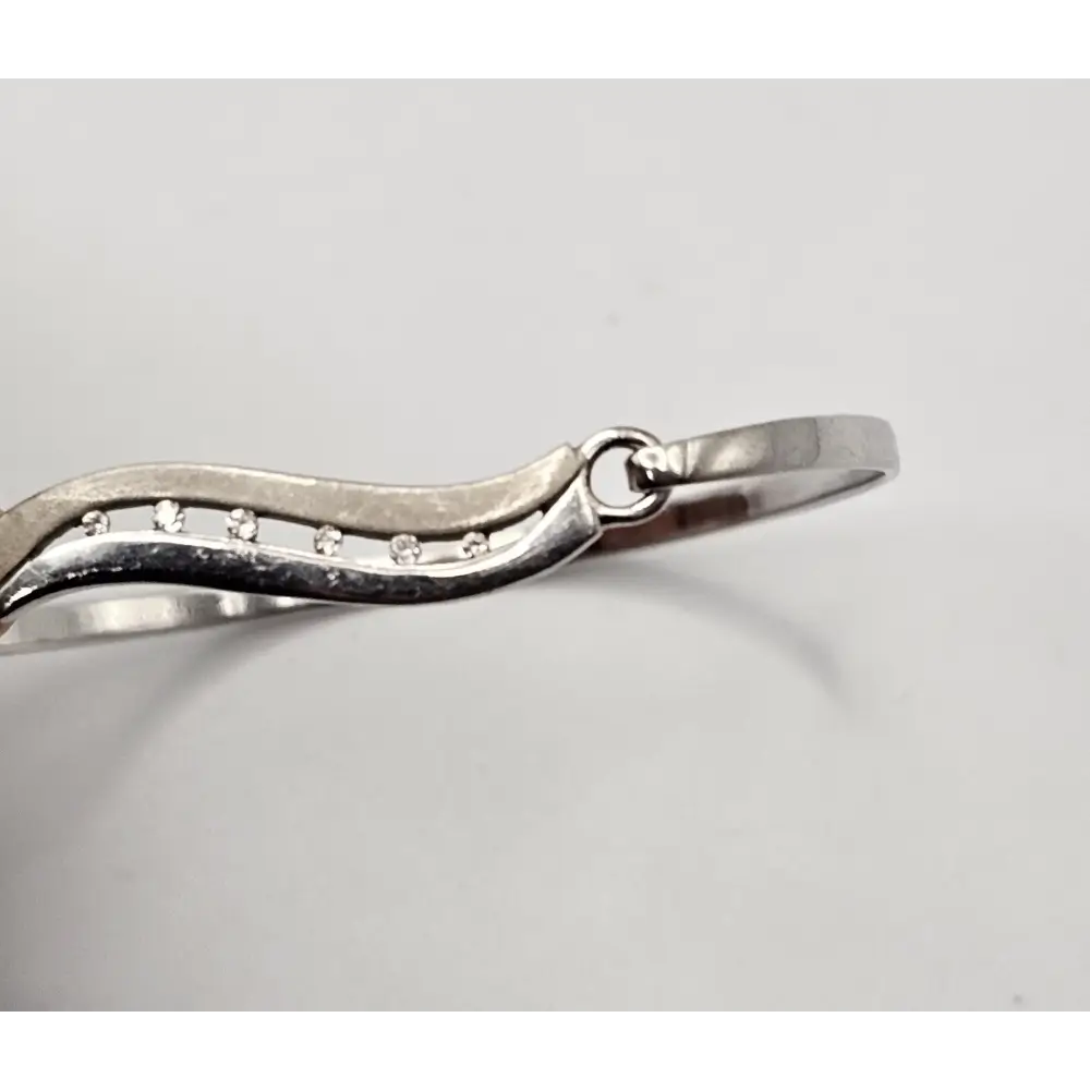 Silver bracelet with small stones on a light gray background