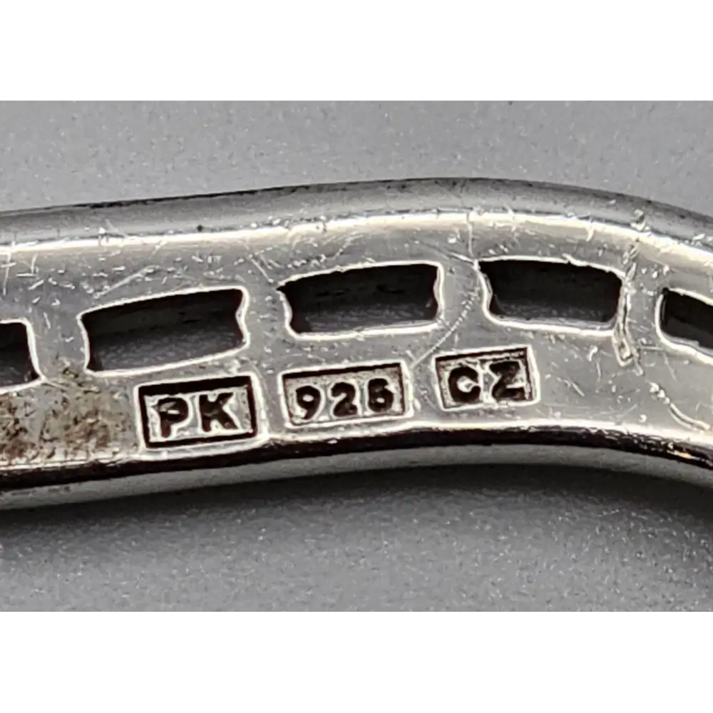 Close-up of a silver ring with visible hallmarks