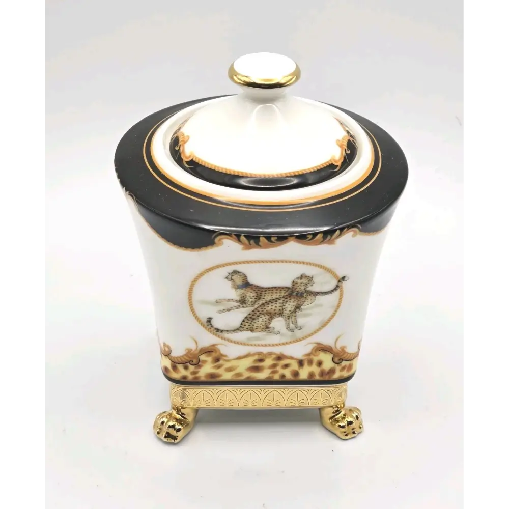 Decorative ceramic jar with black lid, gold accents, and leopard design