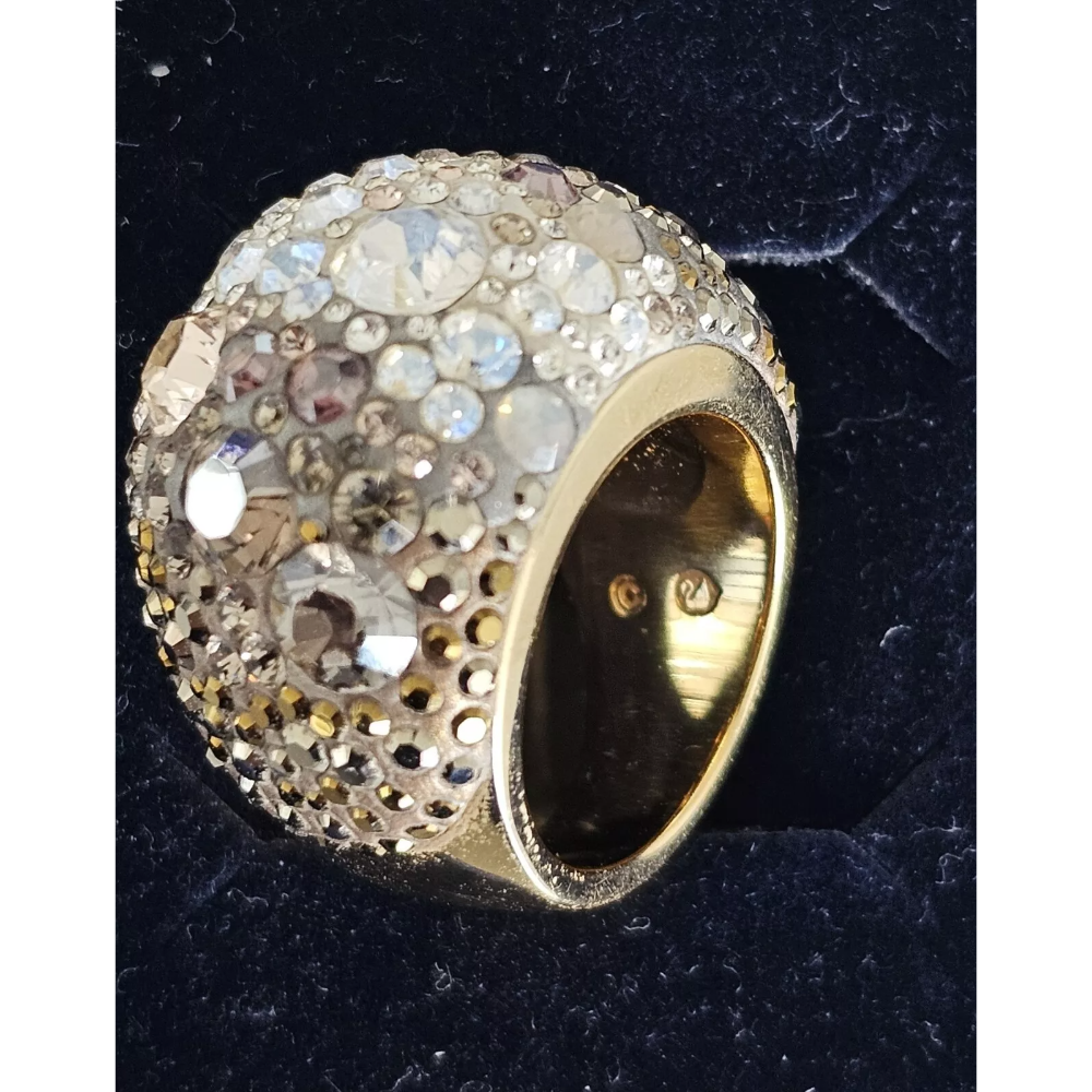 Gold ring with gemstone embellishments on a dark background
