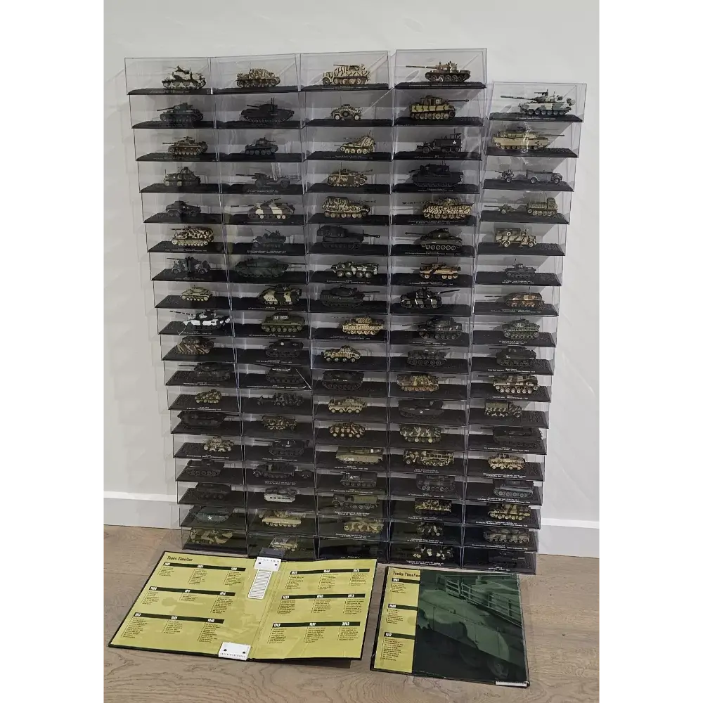 Collection of model tanks in clear display cases on a wooden floor with brochures.