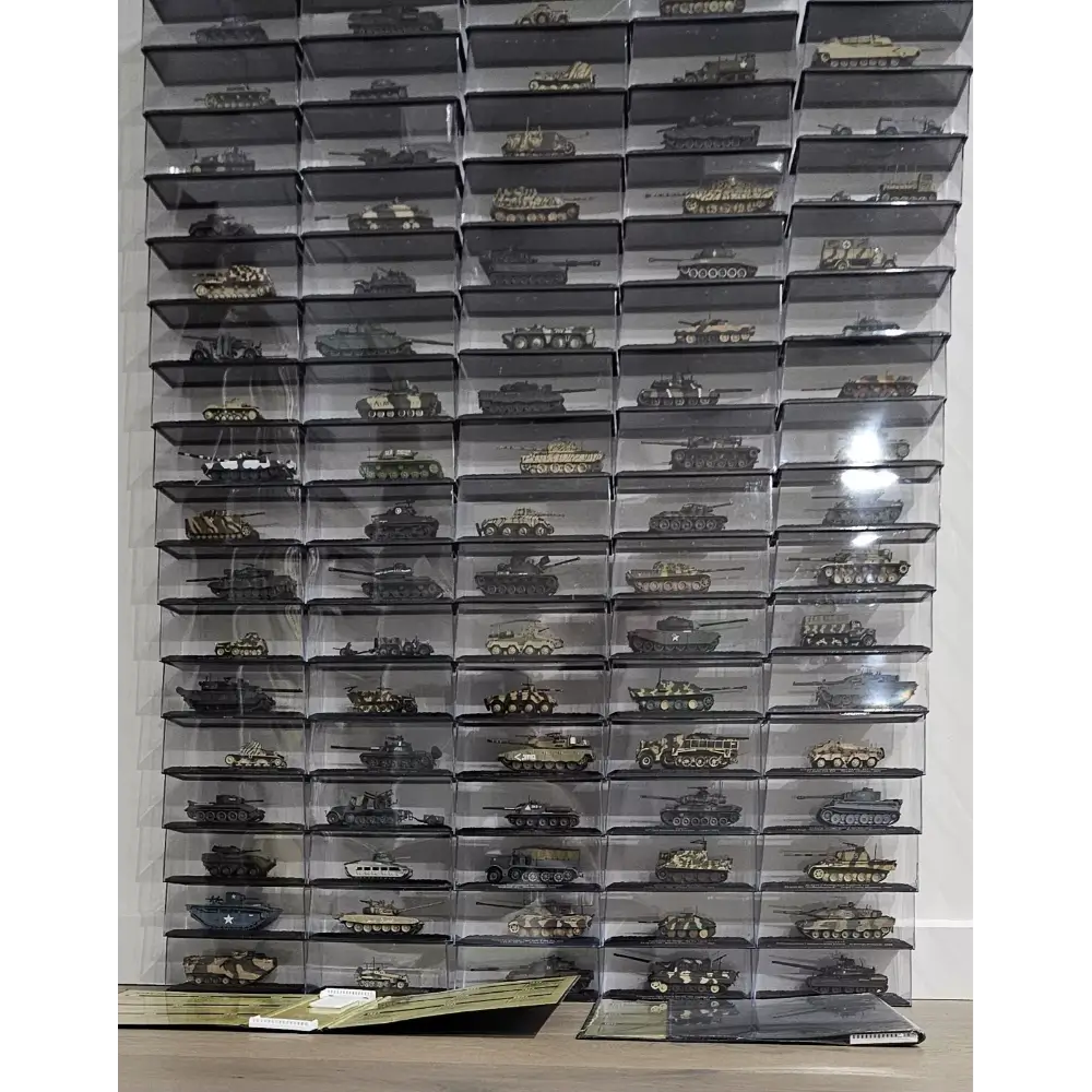 Collection of model tanks in transparent boxes on a wall.