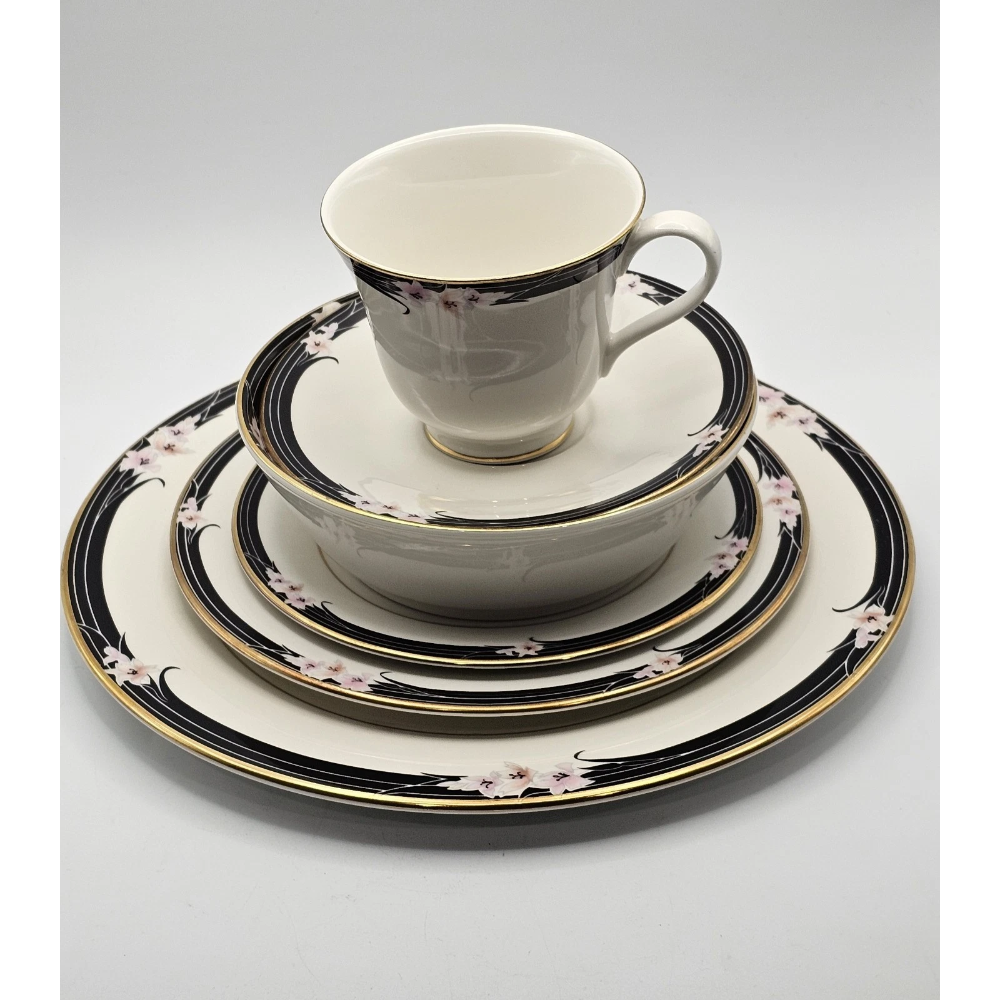 Set of white ceramic dinnerware with black and gold trim