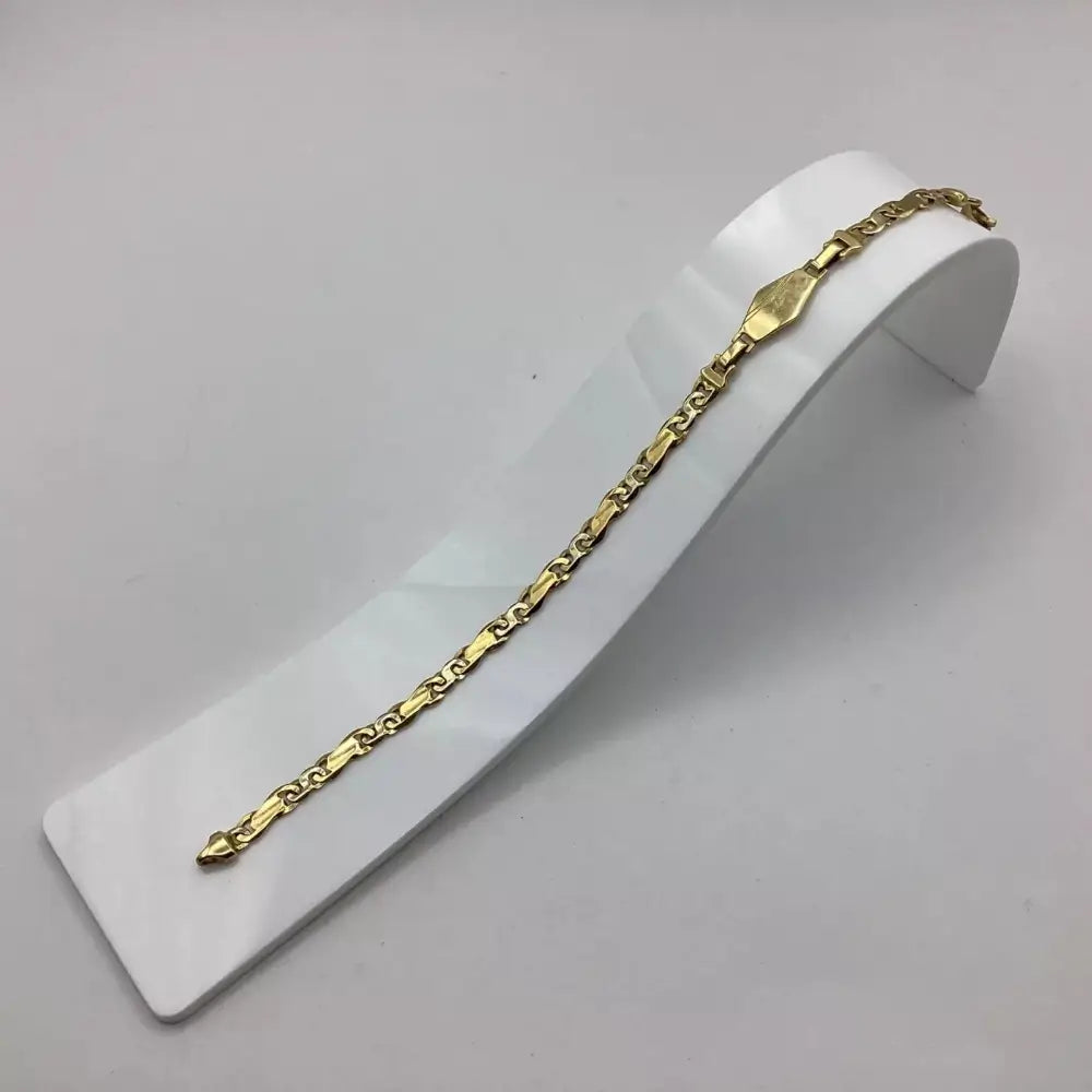 Gold chain bracelet on a white stand