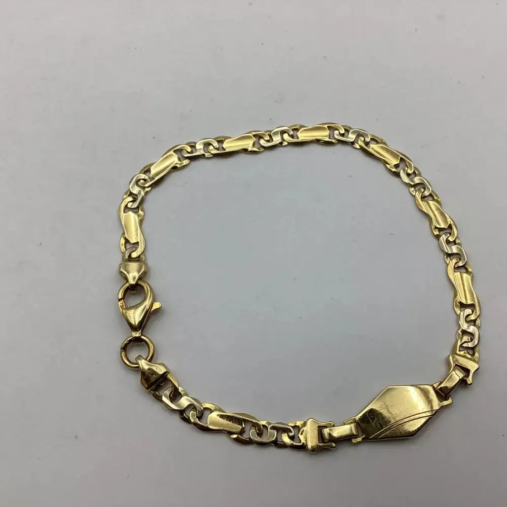 Gold chain bracelet on a gray background