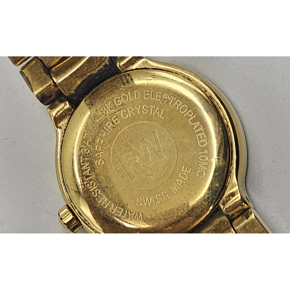 Gold watch case with brand engraving on a gray background