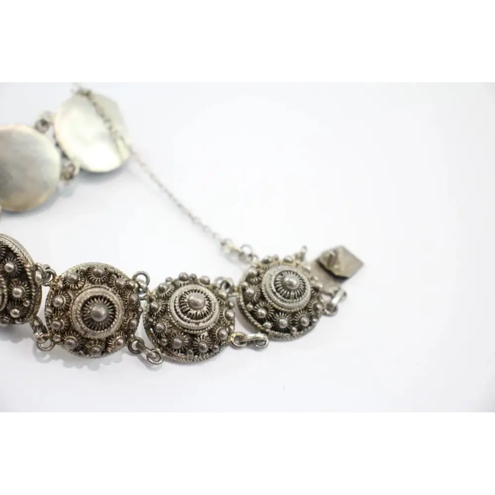 Silver bracelet with intricate designs on a white background