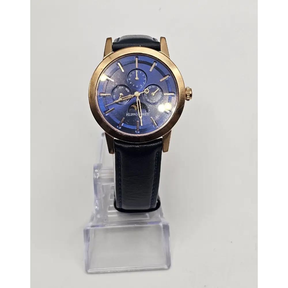 Wristwatch with blue face and black strap on a clear stand