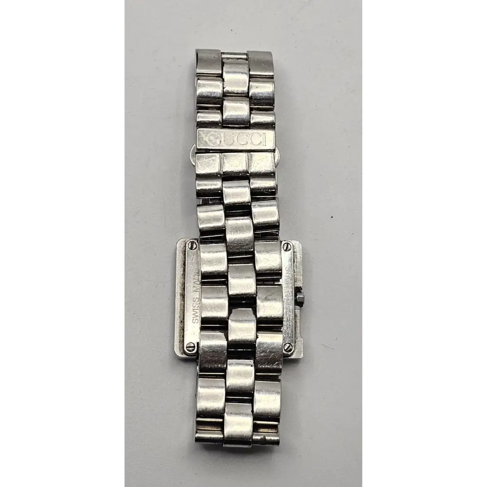 Silver watch band on a gray background