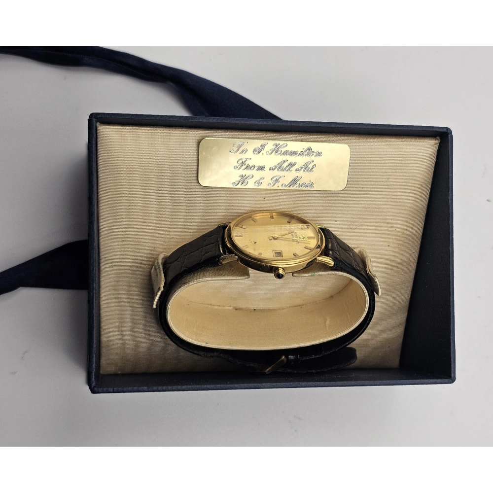Gold watch in a box with a label