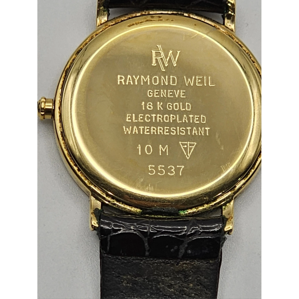 Gold watch case with 'Raymond Weil' branding