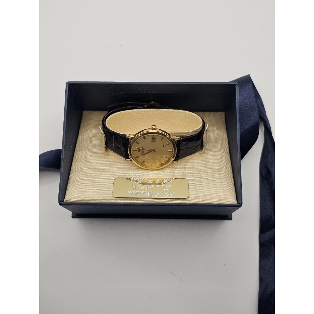 Gold watch with black strap in a box