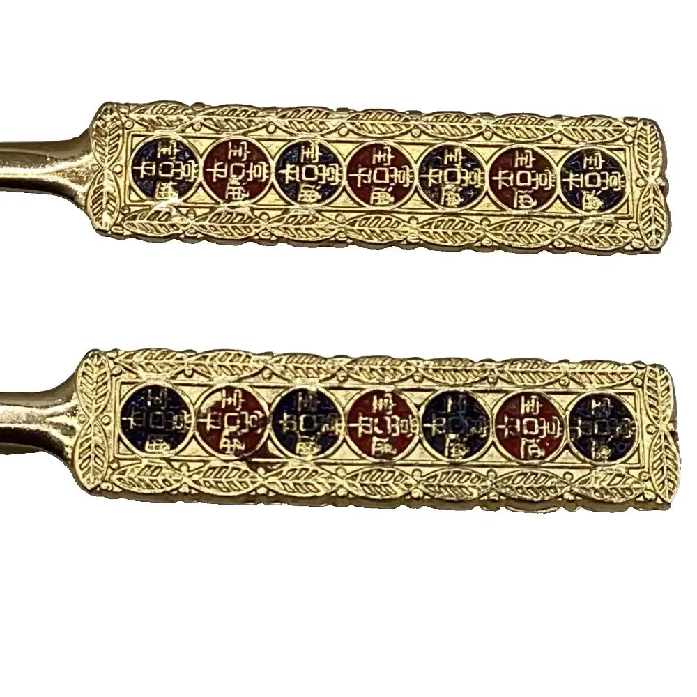 Two gold-colored objects with intricate designs on a white background