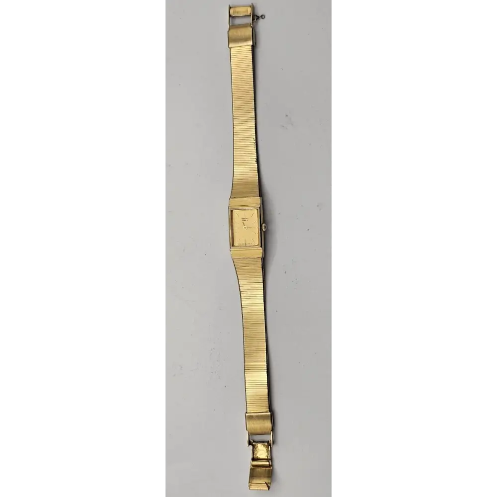 Gold watch strap on a gray background