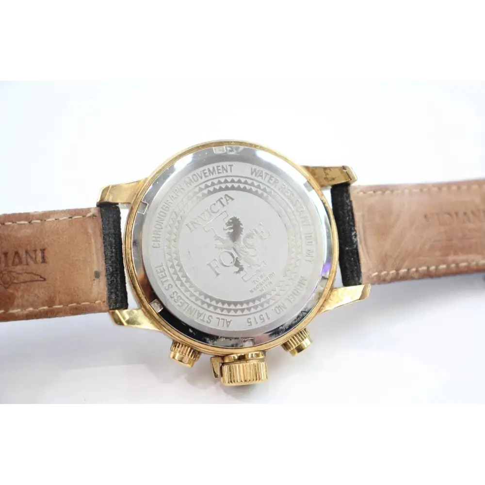 Watch with gold case and brown leather strap on a white background