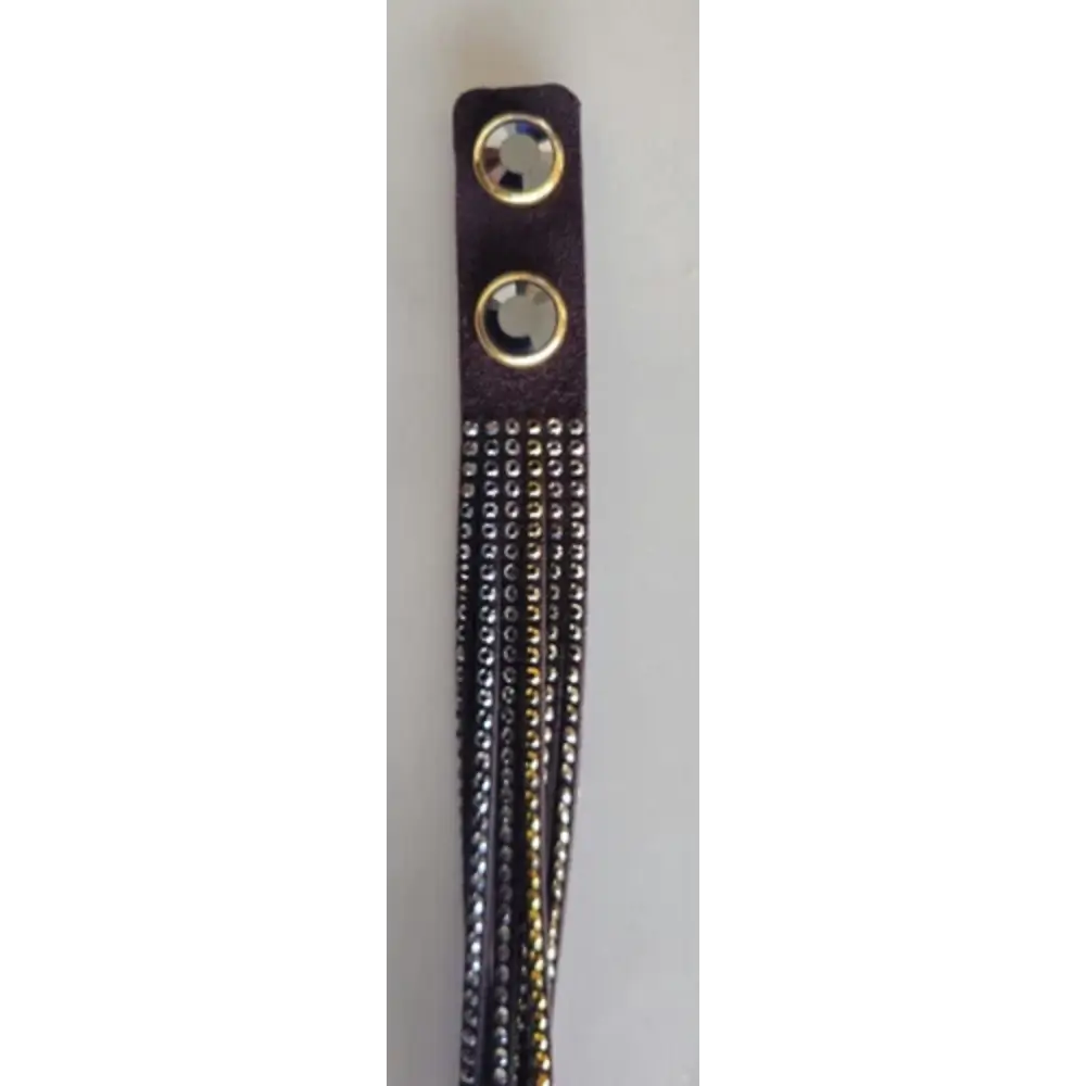 Close-up of a decorative strap with beads and gold accents