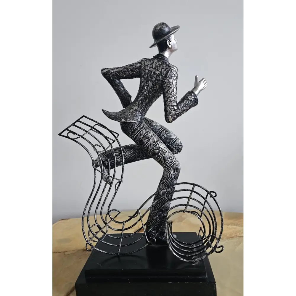 Decorative sculpture of a man sitting on a musical note