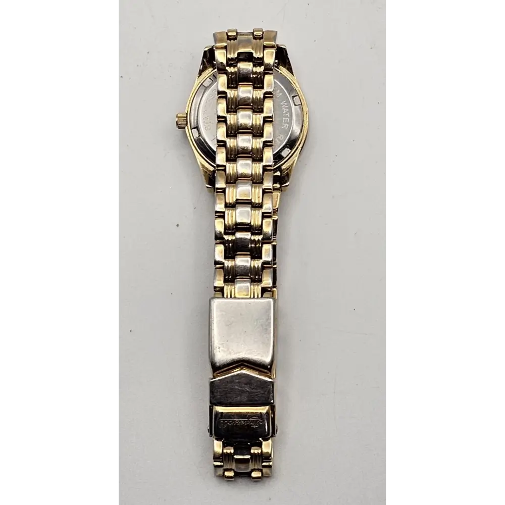 Gold and silver watch on a gray background