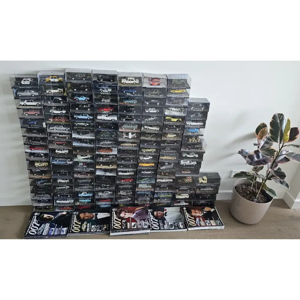 Stack of model car boxes with magazines on a white surface