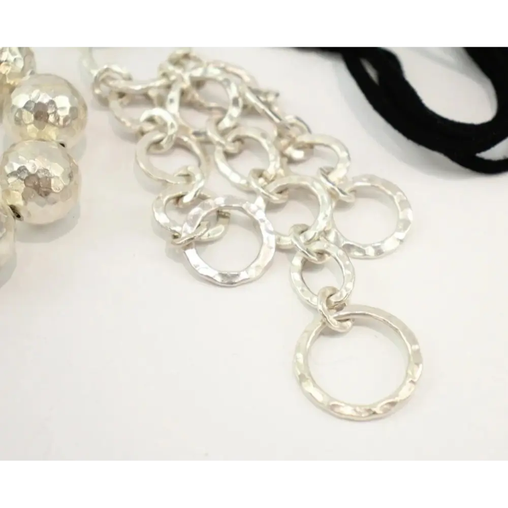 Close-up of a silver chain necklace on a white background