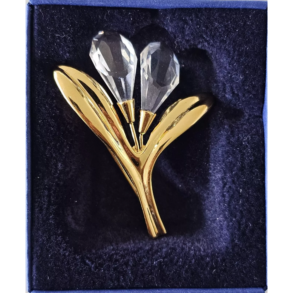 Gold and crystal brooch on a dark blue background