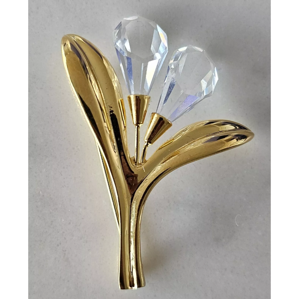 Gold and crystal decorative item on a light gray background