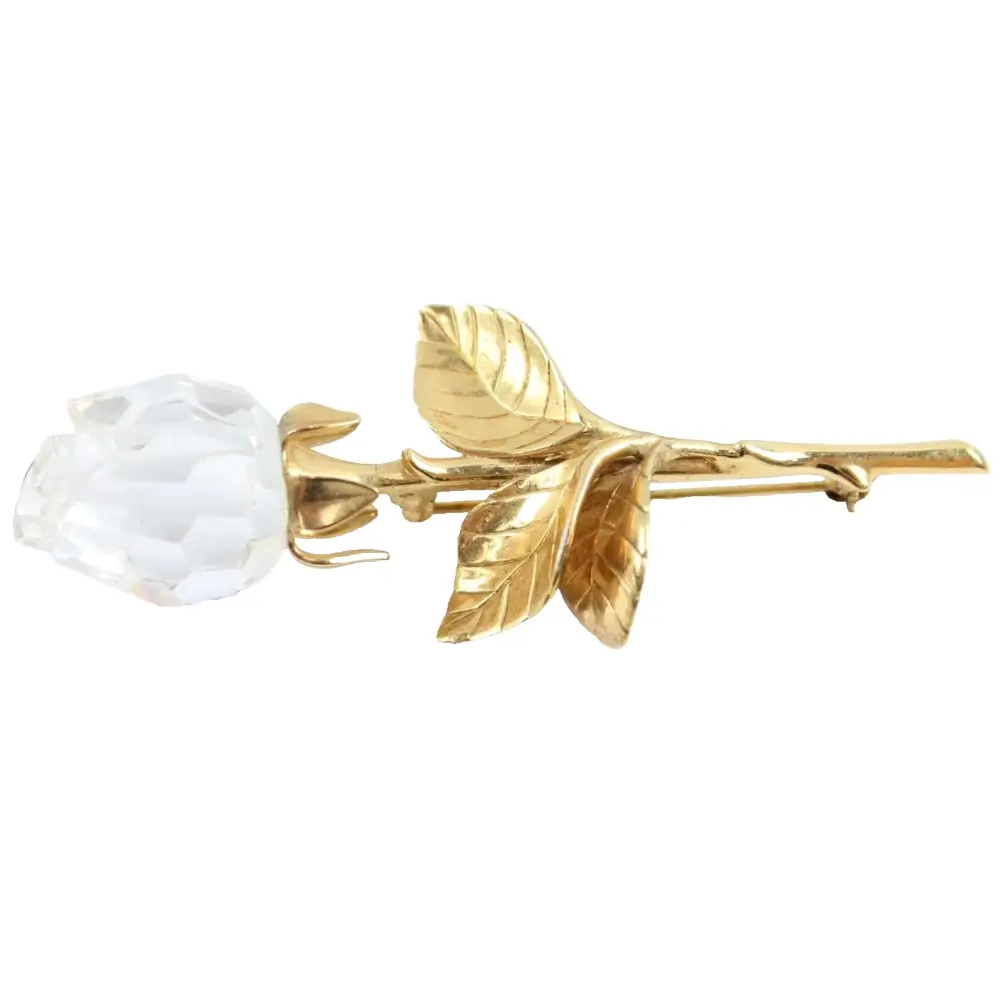 Gold rose with a white stone on a white background