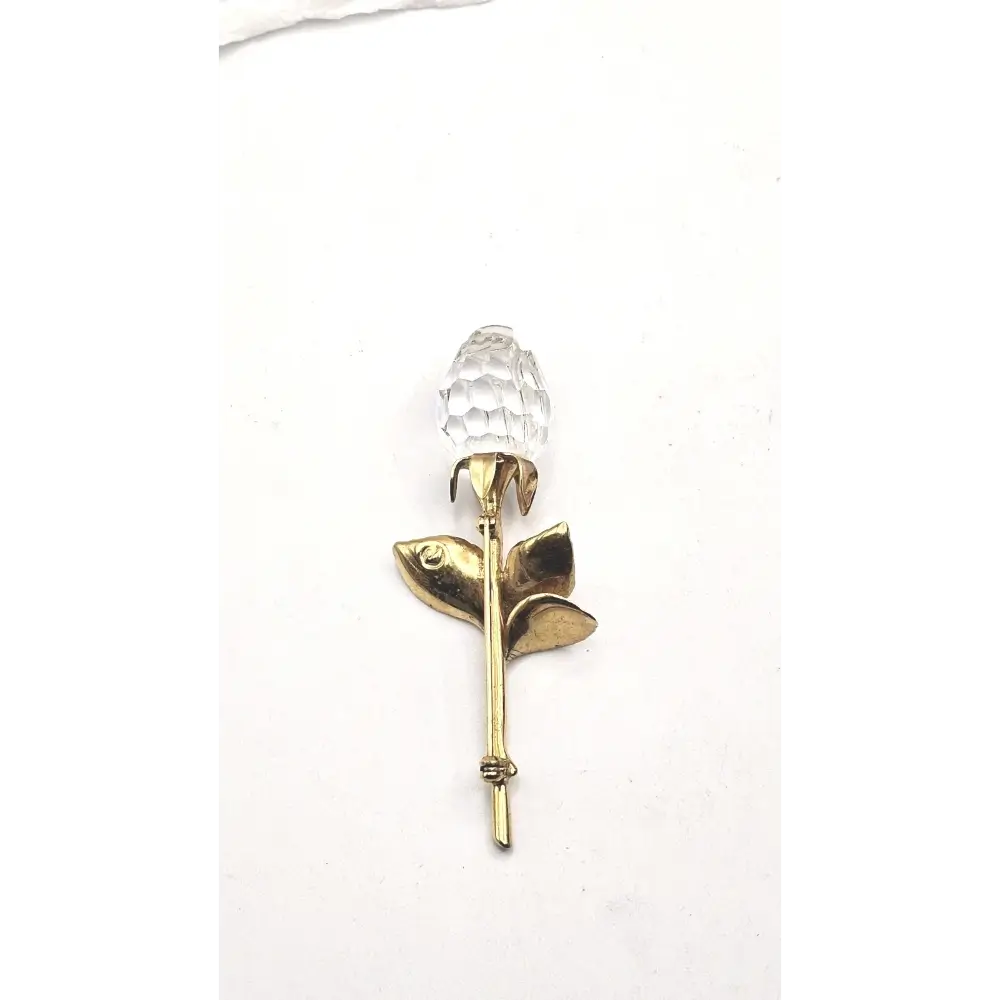 Gold Brooch with a clear crystal on a white background