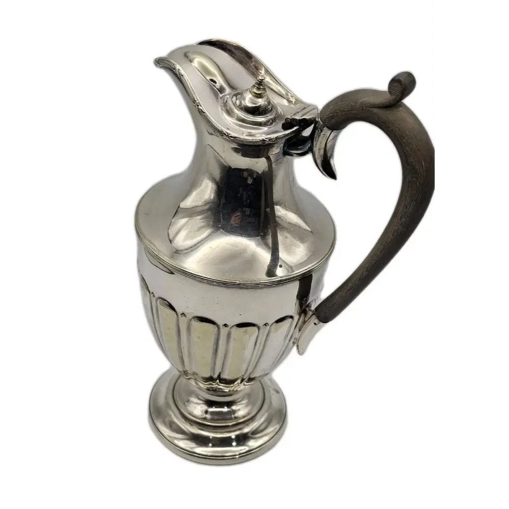Silver pitcher with a black handle on a white background