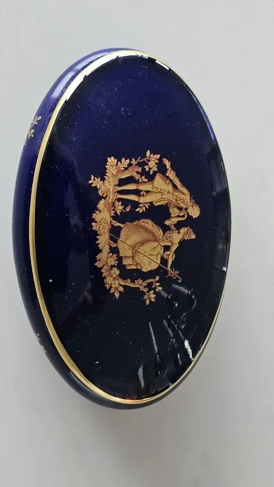Blue decorative item with gold emblem on a gray background