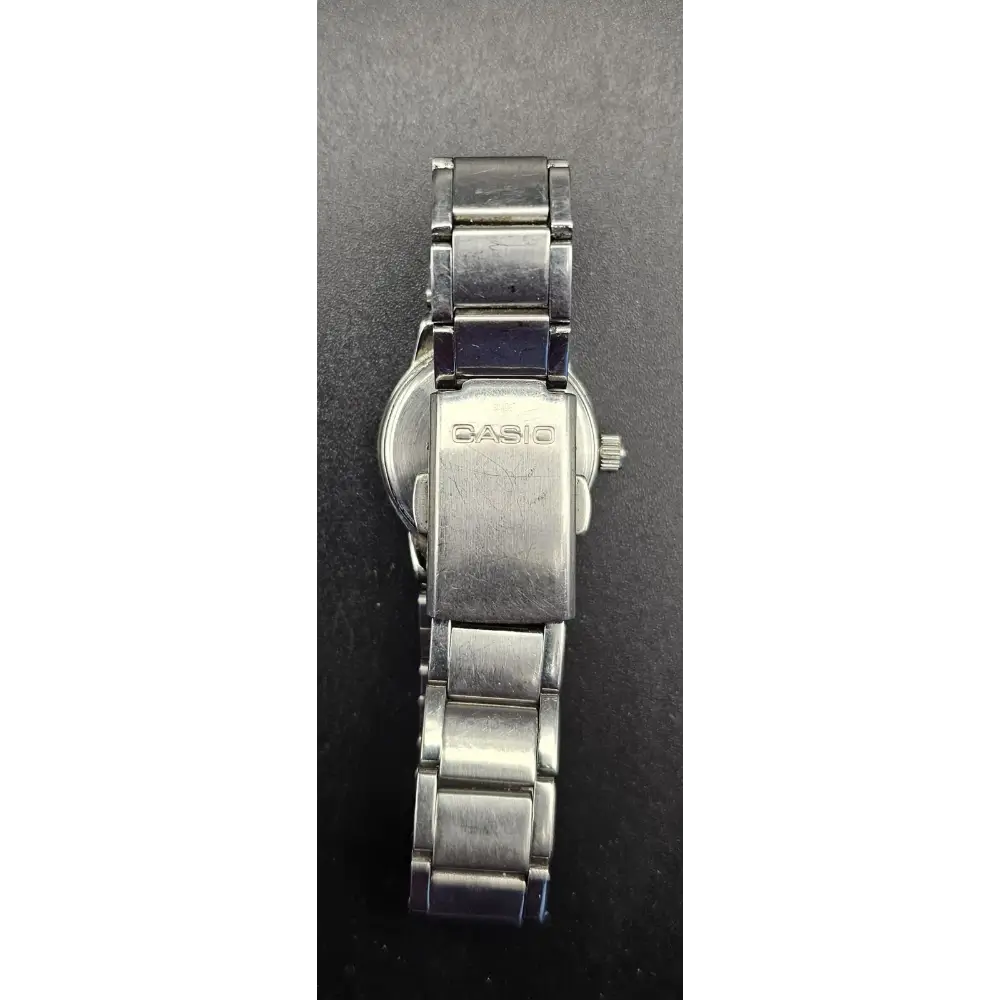 Silver Casio watch on a dark gray background