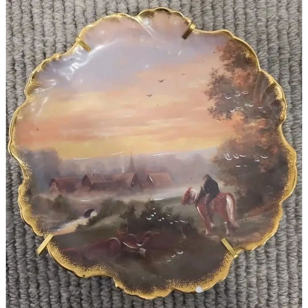 Decorative plate with a scenic painting of a village and people