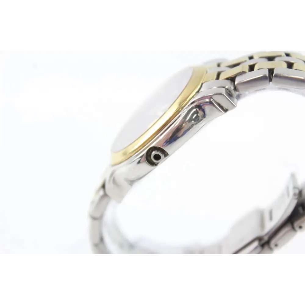 Close-up of a watch with a gold and silver band