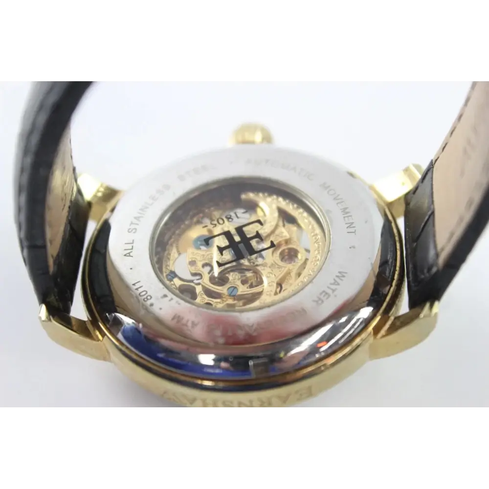 Close-up of a gold watch with a visible brand logo