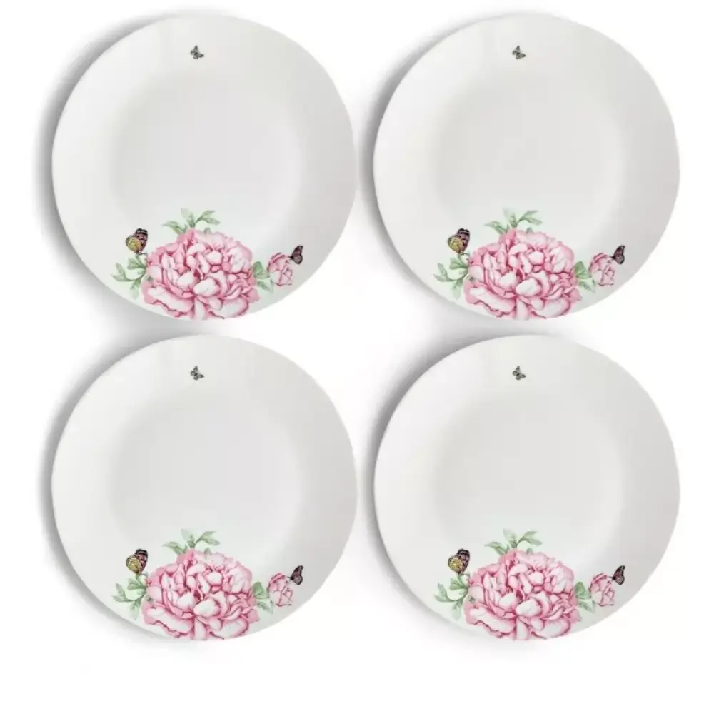 Four white plates with pink floral designs
