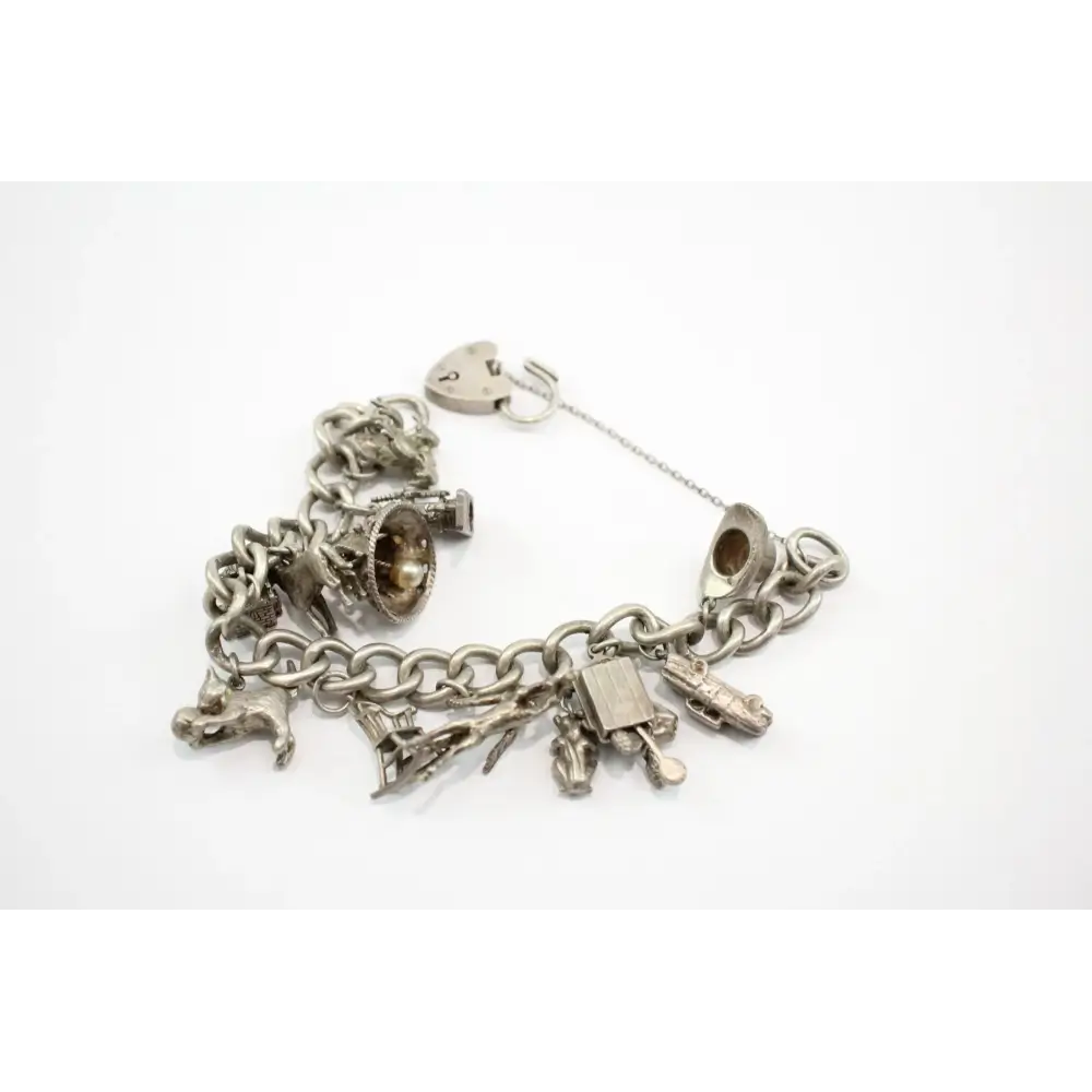 Silver charm bracelet with various charms on a white background