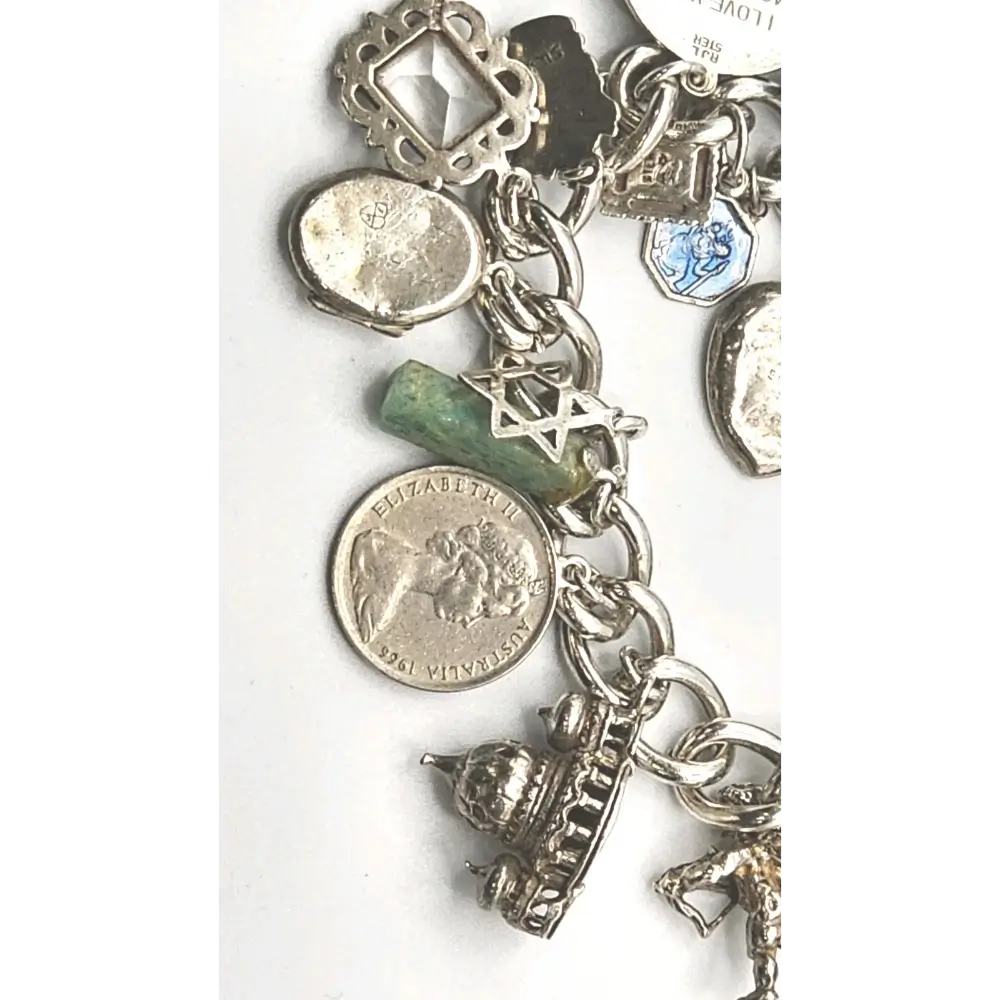 Silver charm bracelet with various charms on a white background